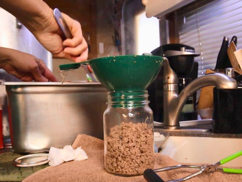 filling a canning jar with ground venison