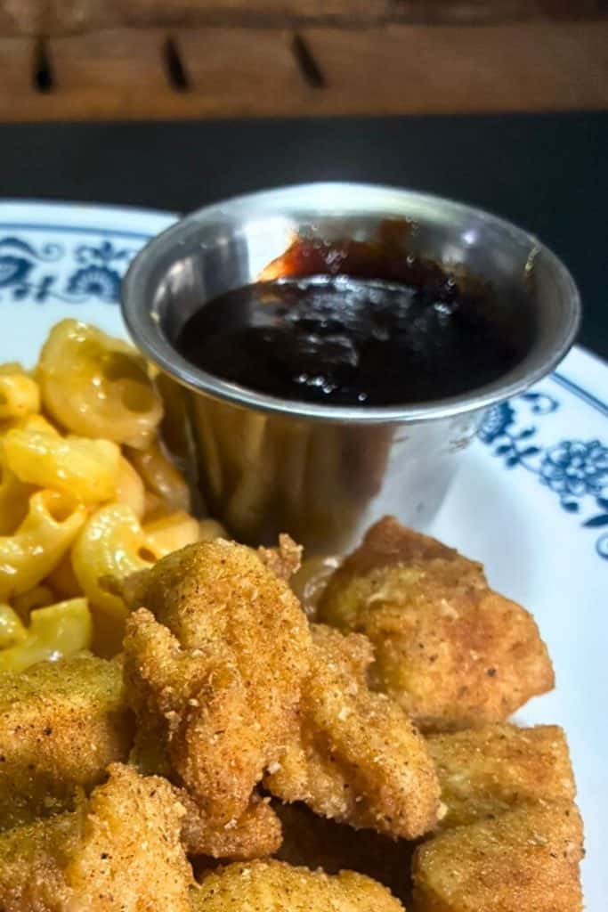BBQ sauce in a cup with chicken nuggets