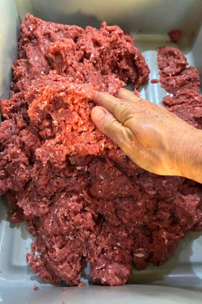 kneading seasoing into ground pork