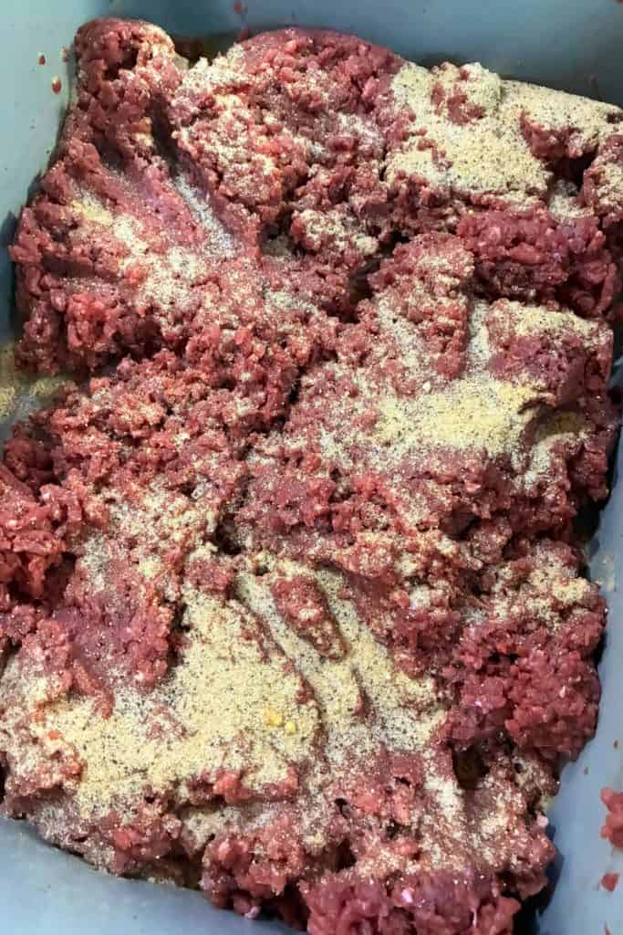 seasoing spread evenly over ground pork