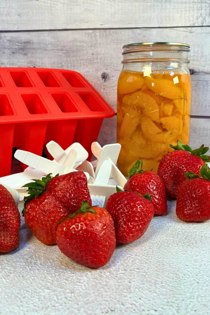 popscile mold and a jar of peaches and strawberries